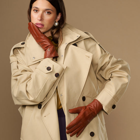 Cognac brown leather gloves with smooth surface and visible stitched paneling