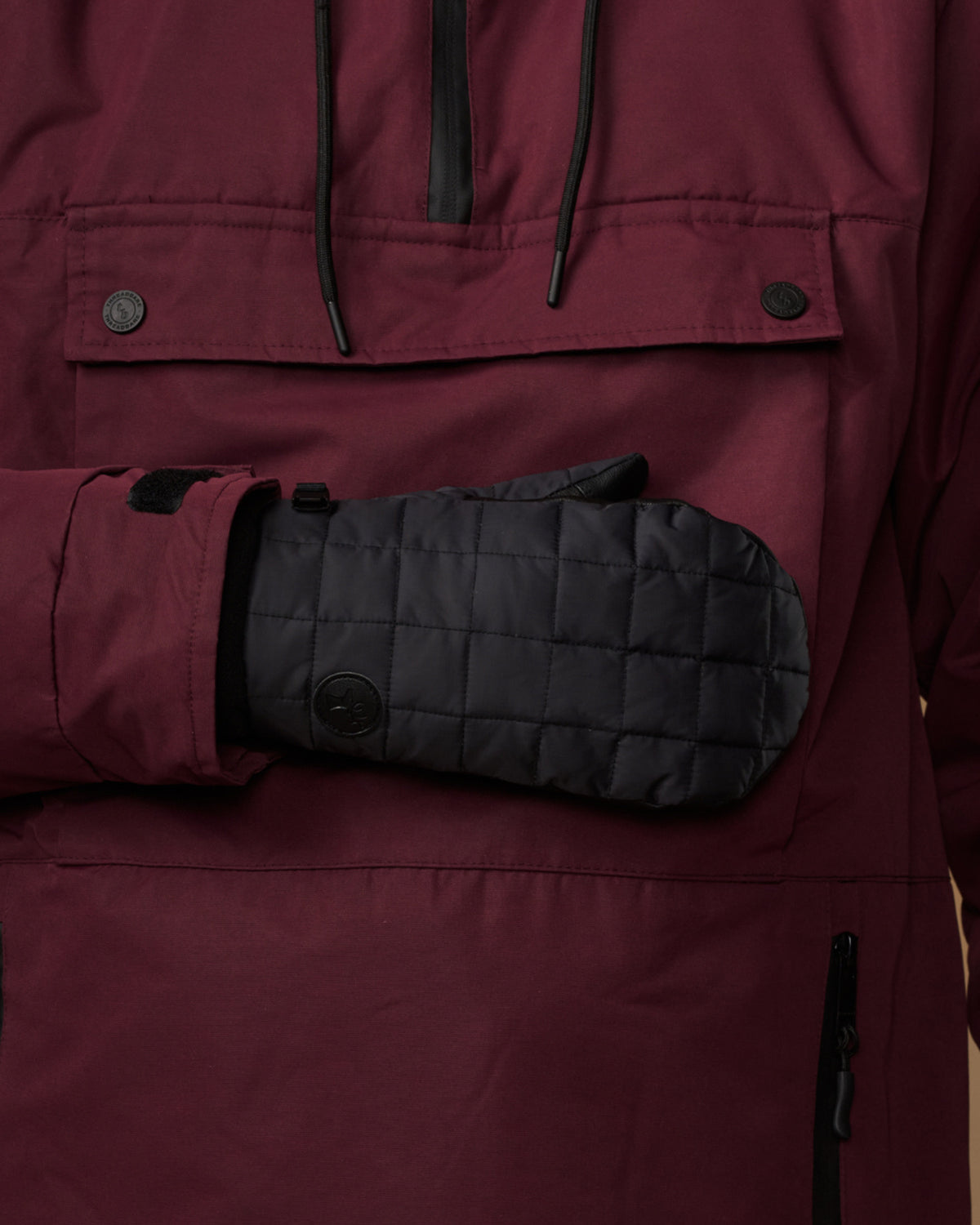 Black quilted mitten with a snap detail and long cuff.