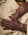Dark brown lambskin gloves with gold-tone buckle hardware and shaped finger panels