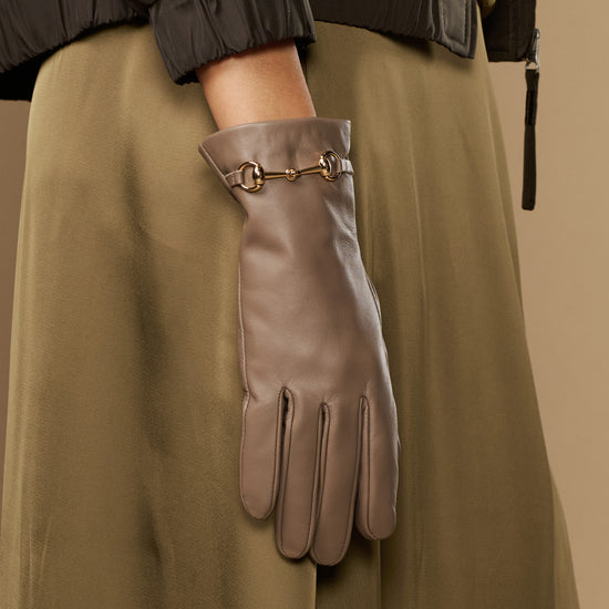 Taupe leather gloves with gold-tone buckle on wrist cuff and five-finger layout