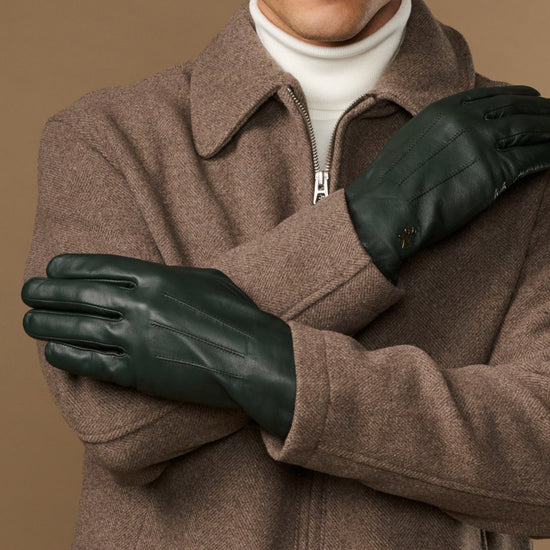 Dark green Jake sheepskin gloves with warm fleece lining, front view with crossed arms