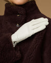 Close-up of women’s white leather gloves with stitched finger seams and tapered cuff