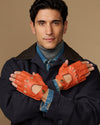 Men's orange fingerless lambskin driving gloves with stitched finger cutouts and cuff tabs