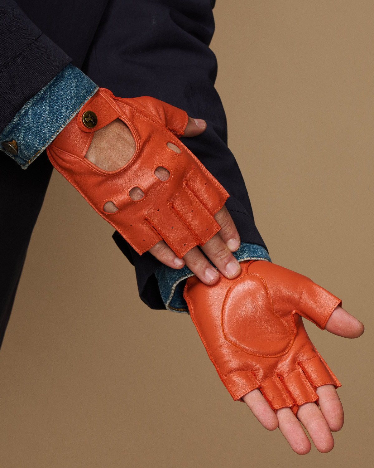 Men's orange fingerless lambskin driving gloves with open finger holes and padded thumb