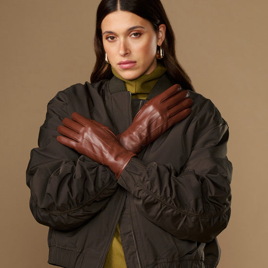 Pair of cognac brown leather gloves with warm fleece lining, snug fit, long cuffs