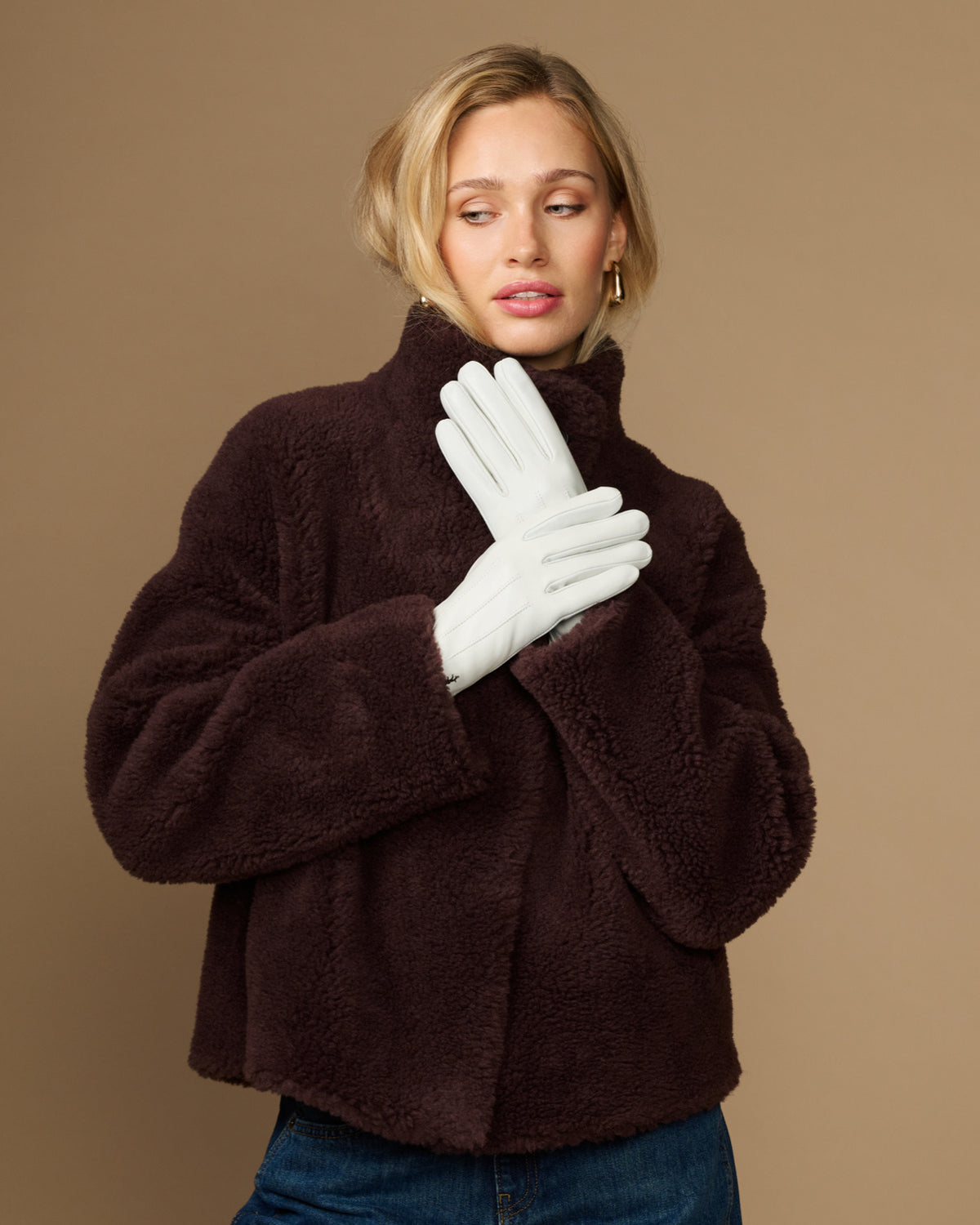 White sheepskin leather gloves with fleece lining, pair covering model's hands