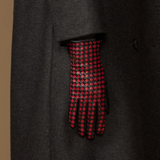 Single women's black leather glove showing red-and-black checkered back and fingers