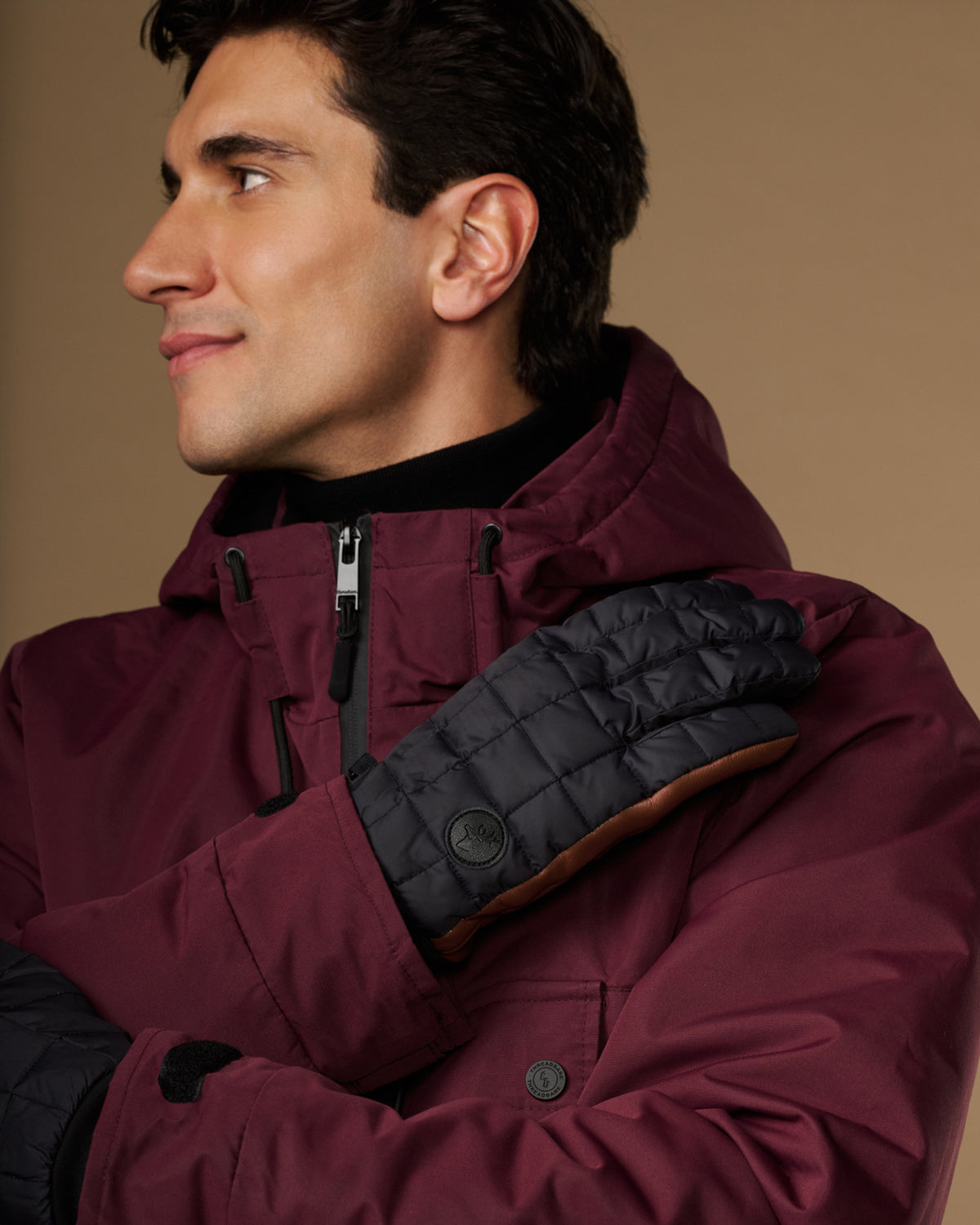 Men's quilted touchscreen glove on hand, dark gray with brown lining