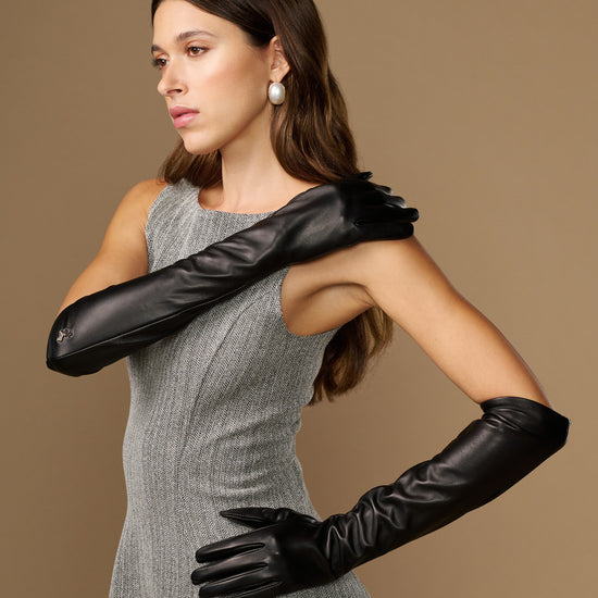 Women’s black leather elbow gloves, side view with arms posed, smooth finish