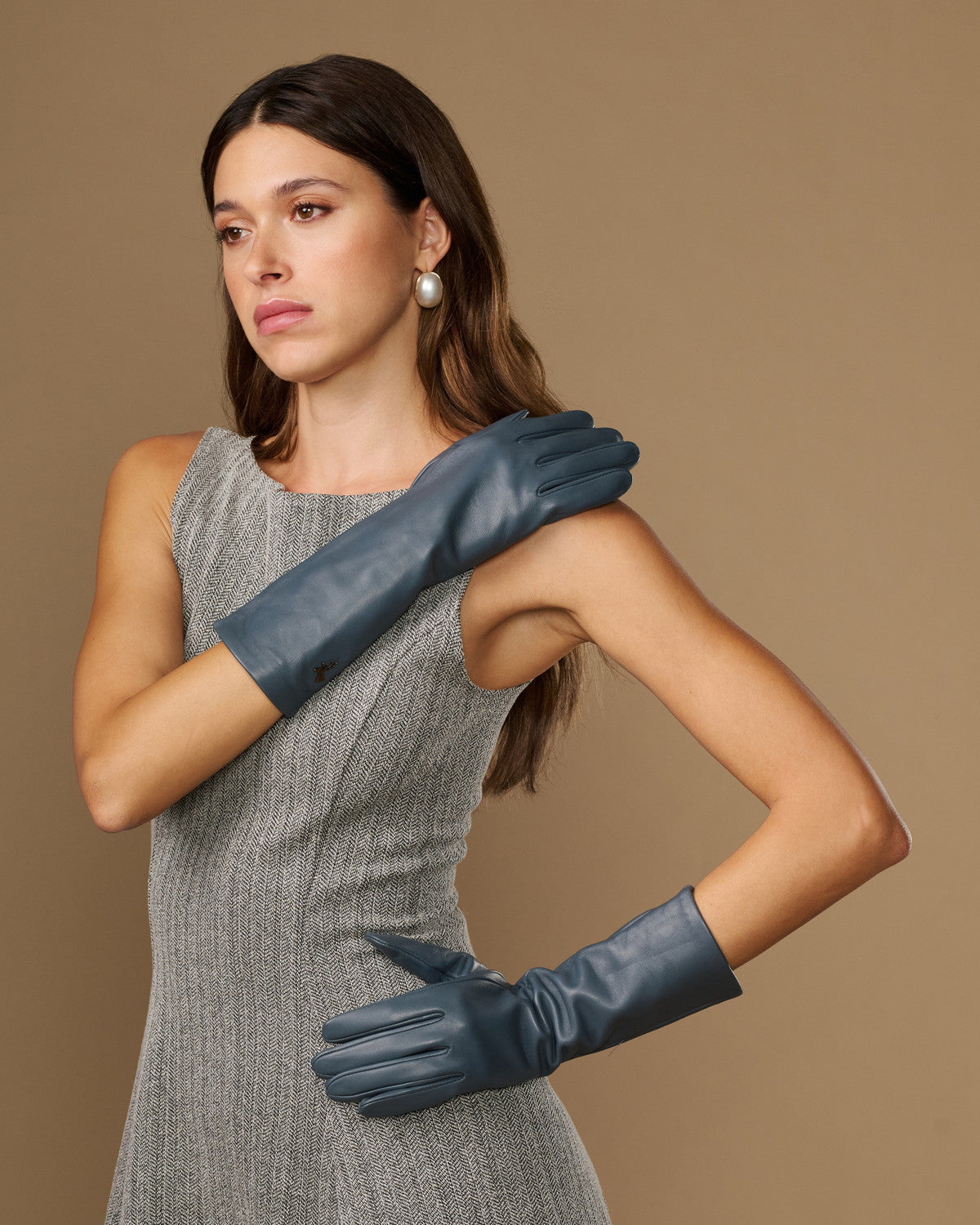 Grey mid-forearm leather gloves with smooth finish and fitted finger seams
