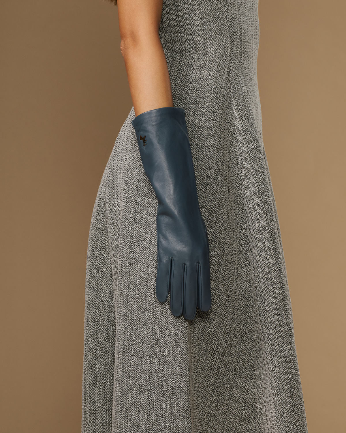 Single grey-blue mid-forearm leather glove with stitched palm and finger panels