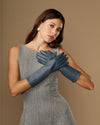 Grey-blue mid-forearm leather gloves with a snug wrist cuff and finger shaping