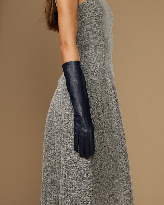 Women’s below-elbow dark blue leather glove on arm, smooth lambskin and snug cuff