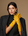 Yellow leather gloves with close-fitting cuffs and stitched fingers, mid-forearm length