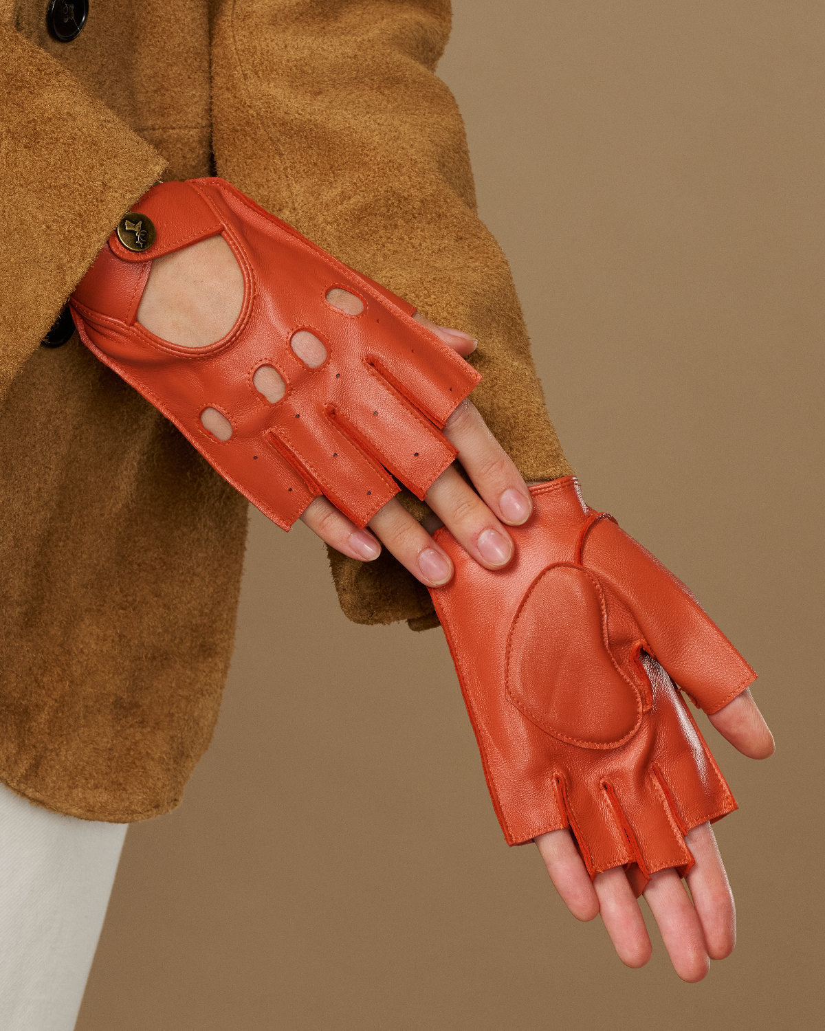 Orange fingerless driving gloves with stitched palm panels and thumb oval cutout