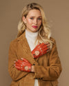 Orange fingerless lambskin driving gloves with open fingers and circular wrist button