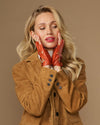 Orange fingerless driving gloves with studded wrist strap and handcuff-style fit