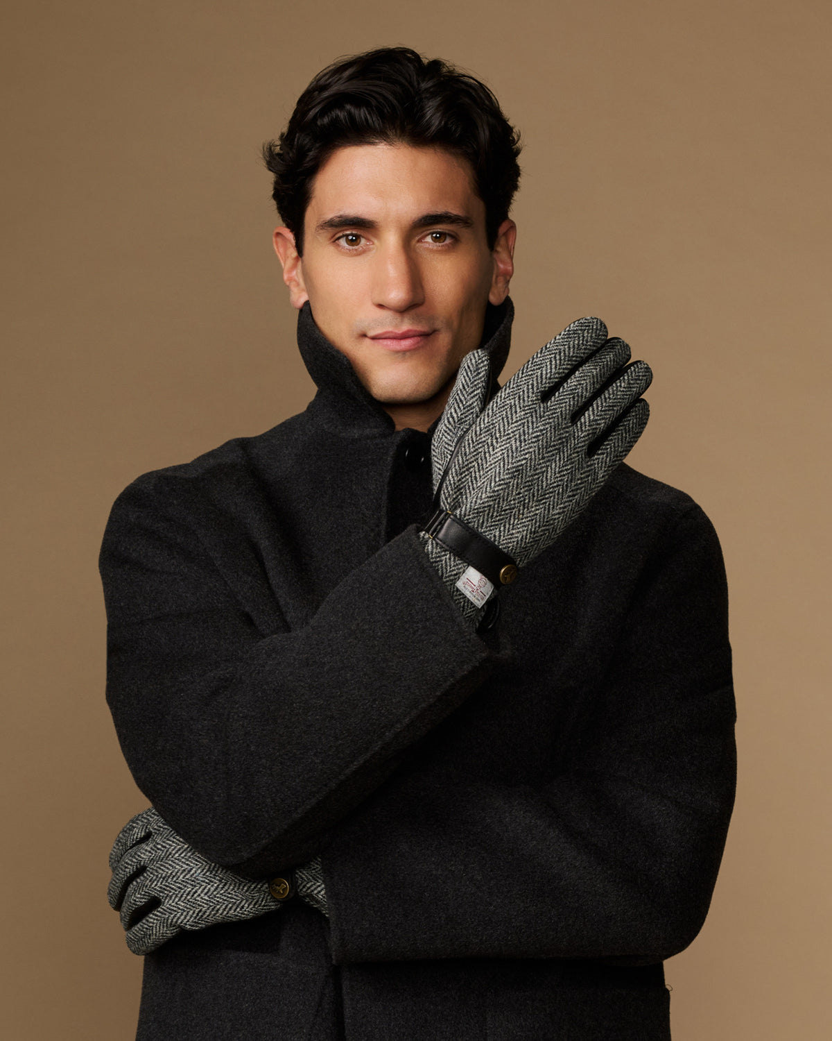 Men's classic gloves crossed: dark felt gloves with gray herringbone detail at wrist.