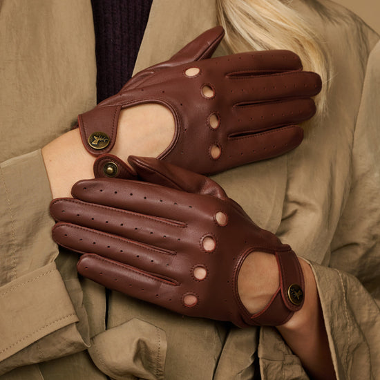 Brown leather gloves with perforated finger panels and decorative button accents