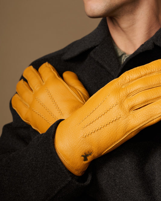 Yellow leather gloves, close-up of palm and finger seams; gray cuff lining